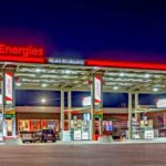 A TotalEnergies fuel station illuminated at night, showcasing the company’s retail network presence.