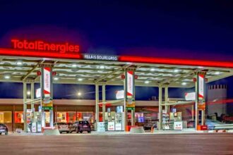 A TotalEnergies fuel station illuminated at night, showcasing the company’s retail network presence.