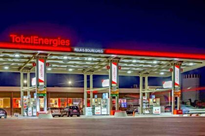 A TotalEnergies fuel station illuminated at night, showcasing the company’s retail network presence.