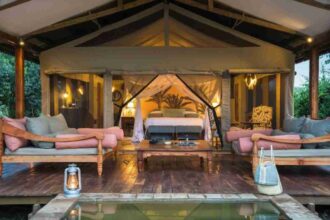 A luxury riverside safari lodge at sunset in Uganda’s Murchison Falls National Park.