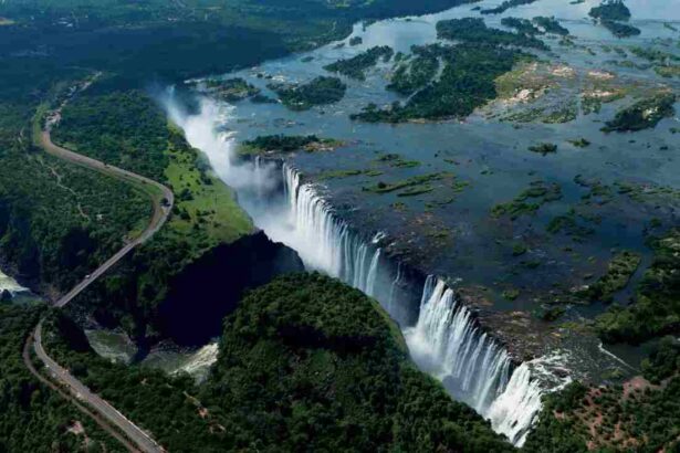 Aerial view of Victoria Falls on the Zambezi River, showcasing the vast gorge and surrounding greenery between Zimbabwe and Zambia