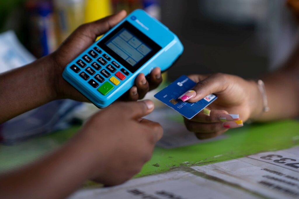 Customer making a payment using a Moniepoint card at a Nigerian retail store.