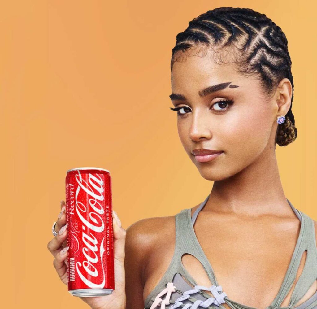 South African music star Tyla holding a Coca-Cola can, promoting the brand in local markets.